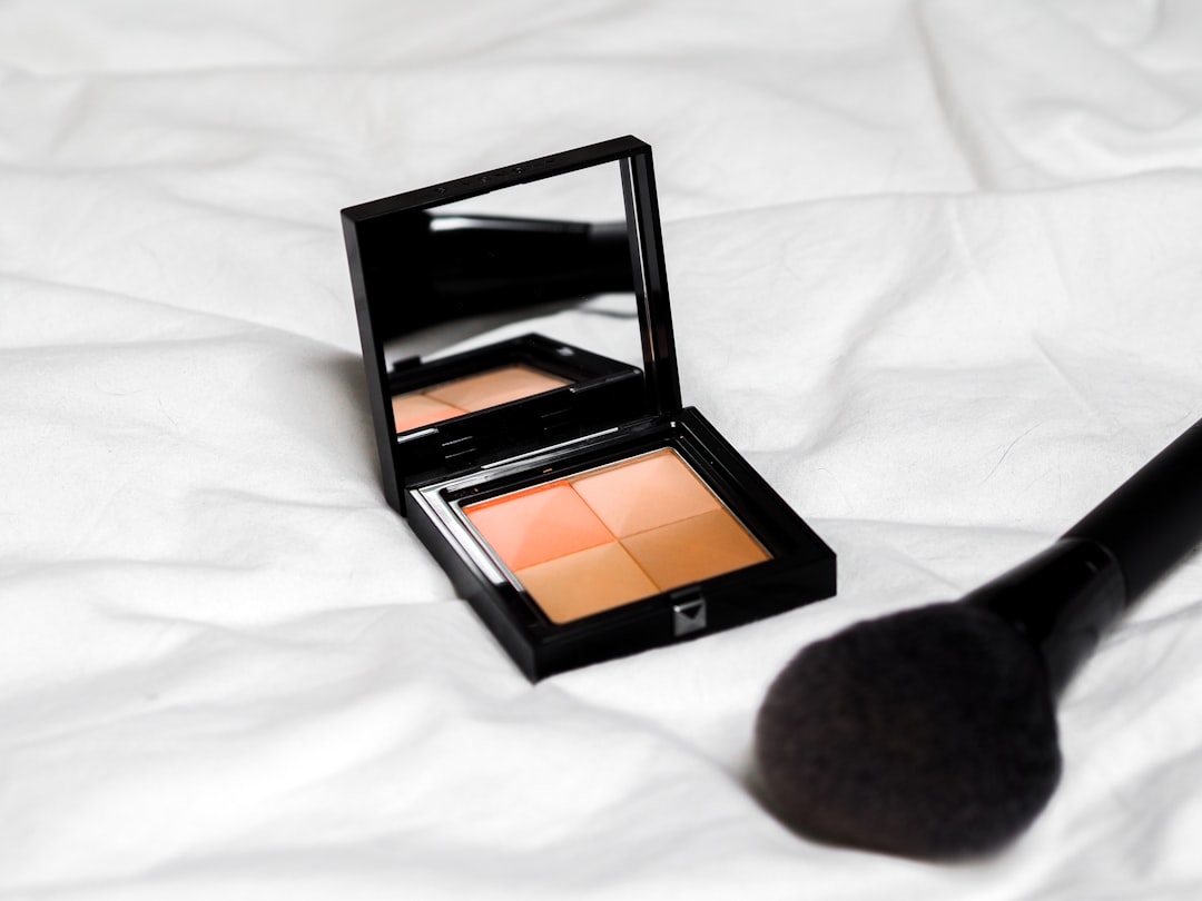 A woman applying contour makeup in front of a mirror, showcasing makeup tools and products.